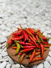Fresh ripe res hot chili pepper on a brown paper on a white stone