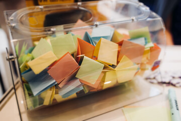 Process of prize drawings, extracting a winning numbers of lottery machine, raffle drum with a bingo balls, bingo machine and winning tickets on event with a female host, hands on lottery machine