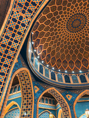 Interior of Turkish Mosque with dome, arches and hand painted ceiling with large chandelier in...