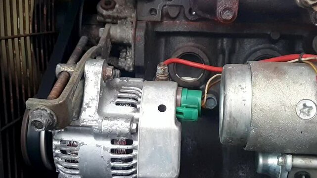 Exploring the mechanics of an engine: a close-up on a working diesel engine, starter and alternator assembly 