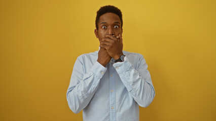 Young african american man isolated over yellow background with shocked expression
