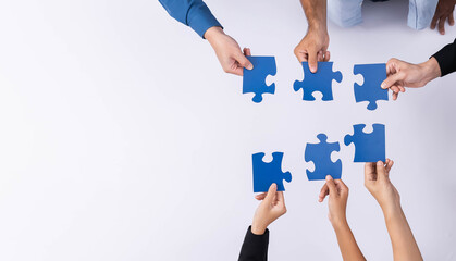 Top view panorama banner of business team joining jigsaw puzzle together over meeting table...