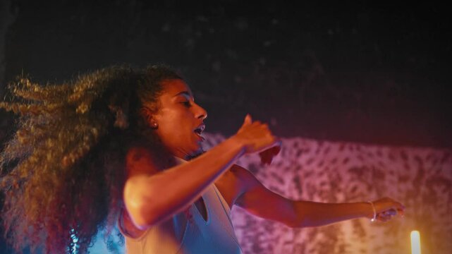Mixed race lady and her boyfriend dancing in studio together, energy of music. Joy and happiness, people moving rhythmically by favorite music, inspiration by Latin dance rhythms, slow motion shot