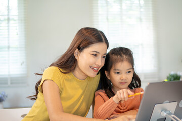 Obraz premium Lovely mom and little young daughter spending time together in their living room.