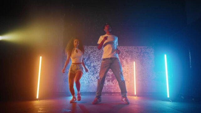 African students of school of arts dancing together in modern dance studio. Young people rehearsing contemporary and ethnic choreography, dancehall and hip-hop dance style, hobby and profession