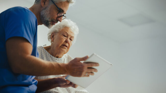 Hospital doctor delivering bed news to old patient, cosulting with her. Old patient with serious health issues suffering from pain.