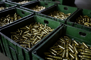 Brass casings stored in green crates at a manufacturing facility