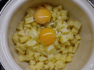 Raw potatoes cut, raw eggs. Food preparation.