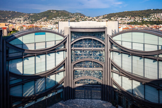 NICE, FRANCE - AUGUST 29, 2019: inner courtyard and glass facades, "Musee d'art moderne et d'art contemporain", called MAMAC,  Museum of Modern and Contemporary Art, city and Mont Boron in background