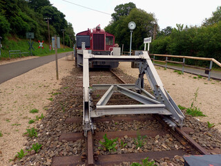 Prellbock an Eisenbahnschienen vor einer Rangierlok Köf II von Deutz im Eisenbahnfreilichtmuseum am ehemaligen Bahnhof in Pronsfeld in der Eifel in Rheinland-Pfalz.