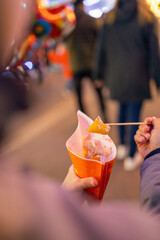 Fresh doughnuts with icing sugar at the Christmas market are eaten by a child.