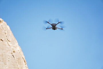 The drone is flying in the air against the sky. Photographing and videotaping nature in the mountains using a quadcopter