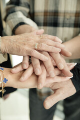 Generationsübergreifende Verbundenheit: Übereinandergelegte Hände von Familienmitgliedern...