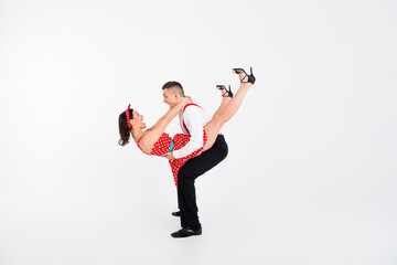 Full size portrait of two young rock and roll dancers hold hands empty space isolated on white...