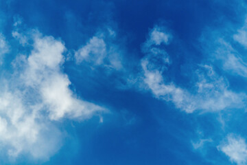 Fototapeta premium Blue sky with moving blurred white clouds, soft focus, blurred contours, dynamics of movement of air masses and aerosols in the air, haze