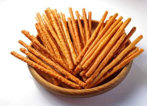 Salgadinho crocante e assado em formato de palito em um bowl, snack, lanche da tarde em fundo branco