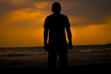 silhouette of a man standing on the beach