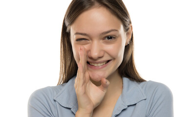 Fototapeta premium Portrait of whispering young woman on white