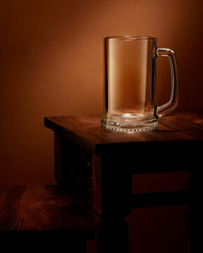 Empty beer glass mug on dark wooden table