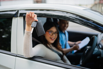 A joyful woman holds her car keys, celebrating the exciting journey shes about to start