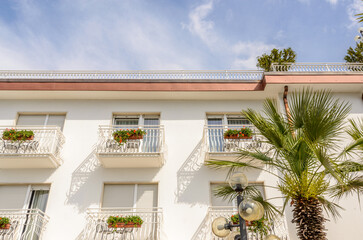 Fragment of a beautiful building with windows decorated with flowers in Italy