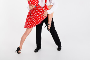 Cropped portrait of two young rock and roll dancers touch perform isolated on white color background