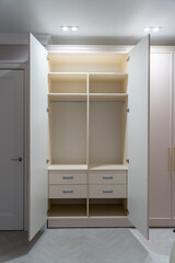 The wardrobe features two open doors, revealing neatly organized shelves and drawers, highlighting efficient storage solutions in a modern design