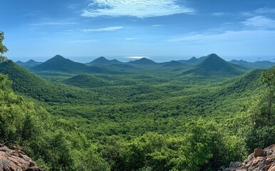 Obraz premium Lush Green Valley Surrounded by Rolling Hills Under a Clear Blue Sky with Gentle Clouds, Perfect for Nature Lover's Dream Destination and Scenic Landscape Photography