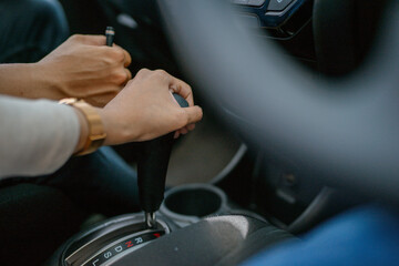 Closeup of hands shifting gears in a vehicle, highlighting the unique driving dynamics