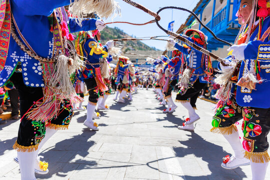 Dancers with masks and traditional costumes celebrate the festivity of the Virgen del Carmen in the square of Paucartambo. Cusco Peru.