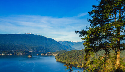 Beautiful Burrard Inlet near Port Moody, with forested mountain backdrop, as viewed from Burnaby Mountain Park, BC.