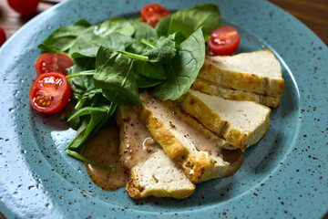 Grilled Chicken with Spinach and Cherry Tomatoes served on a vibrant Blue Plate