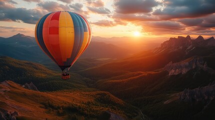 Obraz premium Hot air balloon soaring over majestic sunset mountains.