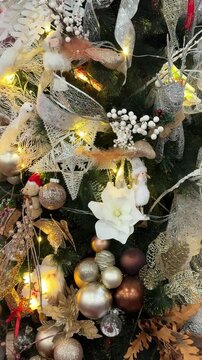 4k footage close up of lighted Christmas tree ornaments and decorations. Mistletoe, baubles, and bell with Interactive sparkling christmas twinkle lights or icicle lights.
