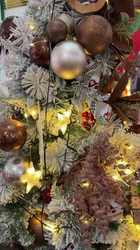 4k footage close up of lighted Christmas tree ornaments and decorations. Mistletoe, baubles, and bell with Interactive sparkling christmas twinkle lights or icicle lights.