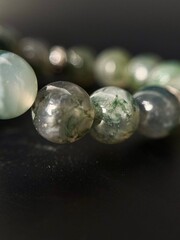 a stylish bracelet made of natural stones with an amulet and inserts made of silver and gold
