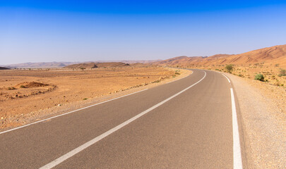 Long road through the Moroccan desert along the Atlas Mountains
