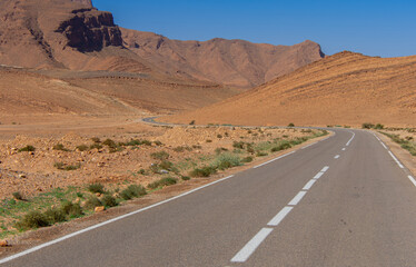 Long road through the Moroccan desert along the Atlas Mountains
