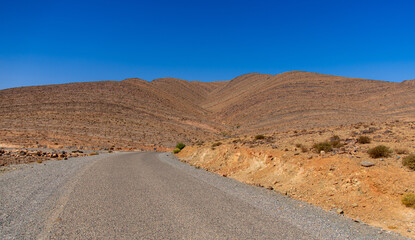 Long road through the Moroccan desert along the Atlas Mountains