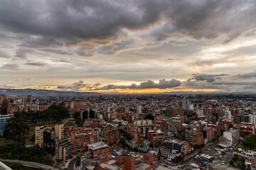 Atardecer dramático sobre Bogotá con nubes densas y paisaje urbano