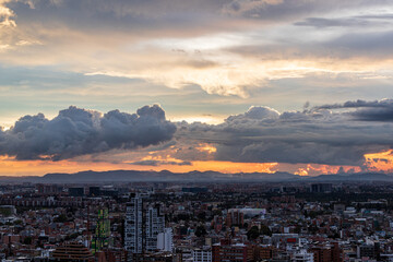Atardecer dramático sobre Bogotá con nubes densas y paisaje urbano