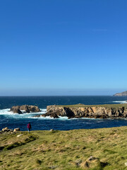 Beach boardwalk sky. Rocks in the ocean. 