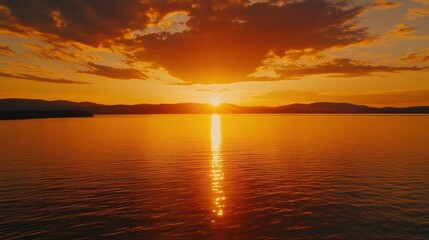 Obraz premium Fiery Sunset Over Calm Lake And Mountains