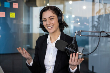 Confident woman in business setting hosting podcast. Smiling expression reflects professional and...