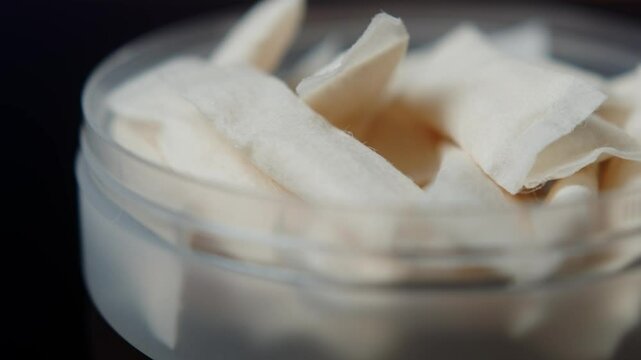 Snus nicotine tobacco close up, pack of tobacco for gum. unhealthy addiction. Man opening box with snus and taking one. 
