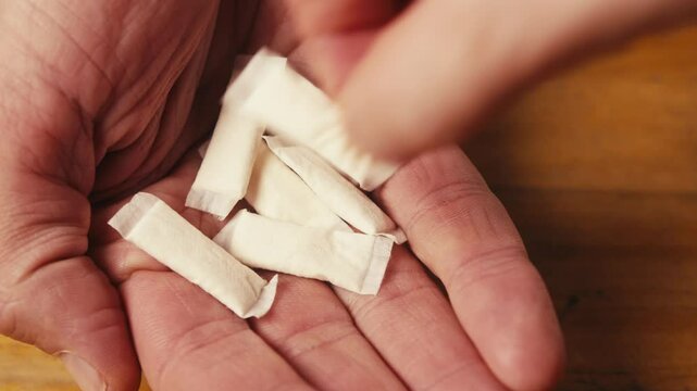 Snus nicotine tobacco close up, pack of tobacco for gum. unhealthy addiction. Man opening box with snus and taking one. 