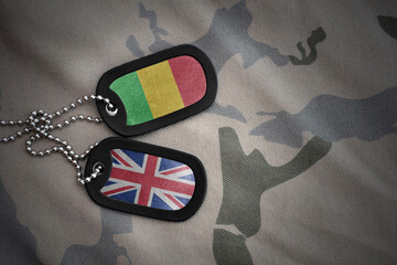 army blank, dog tag with national flag of mali and great britain on the khaki texture background. military concept.