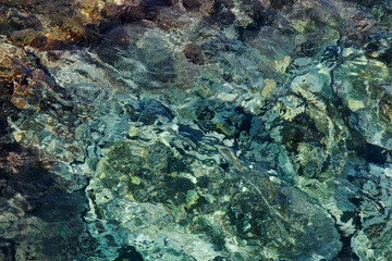 Abstract background with transparent ocean water over rocky bottom