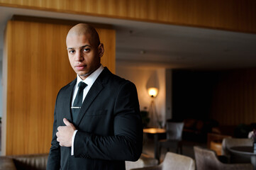 Elegant african american businessman standing in modern lounge of business center