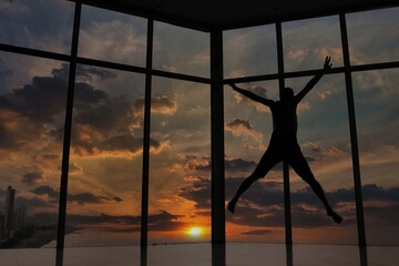 oy jumps walks on the glass 

behind the window sunset
man spider 